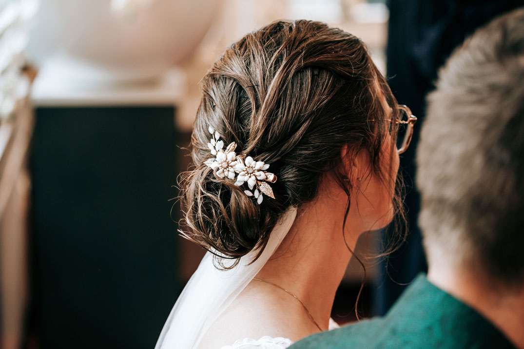 Een mooie foto van het kapsel van de bruid op de trouwdag tijdens de bruiloft.