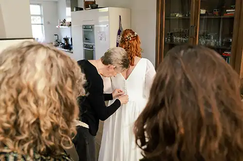 bruiloft-de-baest-oost-west-middelbeers-oirschot-kiemeneij-angela-fotografie-trouwen-trouwfotograaf-baby-16-brabant Bruid wordt geholpen met aankleden.