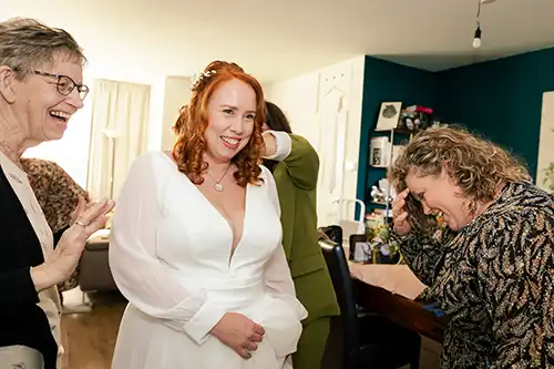 bruiloft-de-baest-oost-west-middelbeers-oirschot-kiemeneij-angela-fotografie-trouwen-trouwfotograaf-baby-18-brabant Bruid wordt geholpen met aankleden.