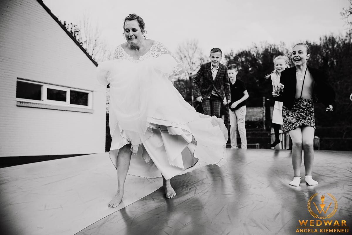 Bruiloftreportage Angela Kiemeneij waar bij de bruid mee gaat spelen met de kinderen in Oirschot