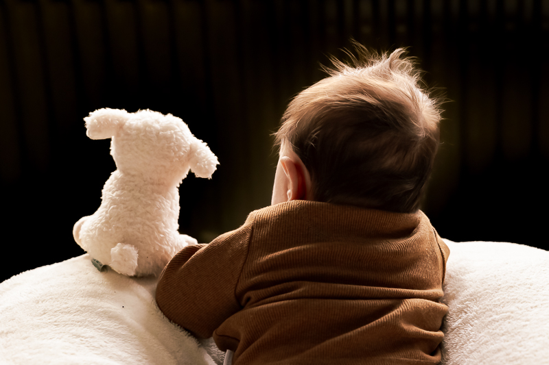 Baby ligt naast een lieve knuffel van een schaap van Little Dutch