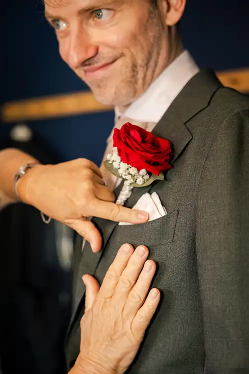 Eindhoven-63 Angela-Kiemeneij-Fotografie-Trouwfotograaf-Veldhoven-Brabant-mrs park-trouwen- Moeder helpt mee met het vastzetten van de corsage op de trouwdag in Eindhoven.